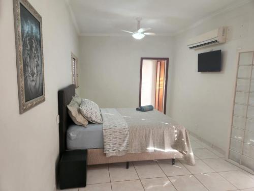 - une chambre avec un lit et un ventilateur de plafond dans l'établissement Repouso Real Rio Preto, à Sao Jose do Rio Preto