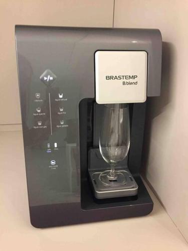 a wine glass in a dispenser with a sign on it at Sobrado com piscina, banheira e garagem coberta. in Piçarras