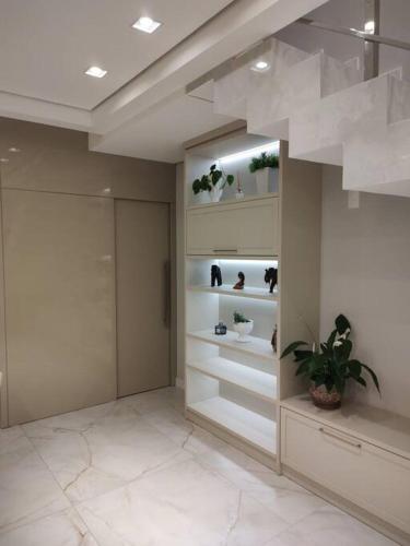 a room with shelves with potted plants in it at Sobrado com piscina, banheira e garagem coberta. in Piçarras