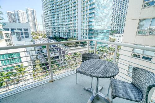 uma mesa e cadeiras numa varanda com edifícios em Prime Location: Midtown Miami Finest Condo em Miami