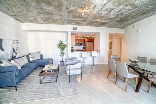 uma sala de estar com um sofá azul e uma mesa em Prime Location: Midtown Miami Finest Condo em Miami