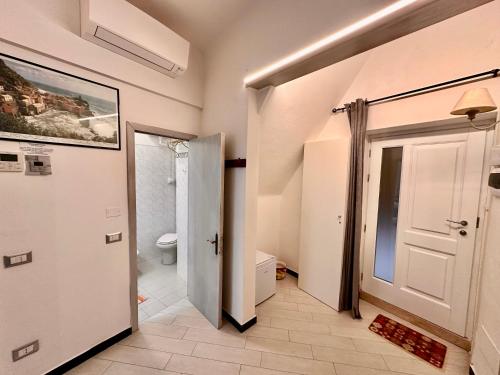 a bathroom with a toilet and a white door at Via Del Santo - FrancamariaDotCom in Vernazza