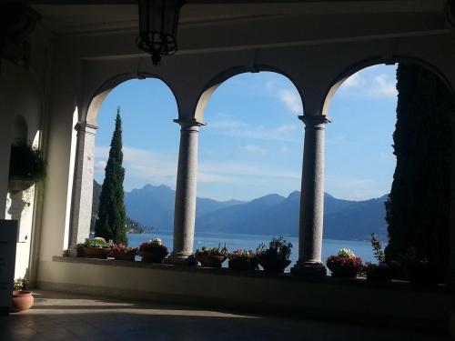 a window in a building with a view of the water at Antico Pozzo Apartment in Bellagio