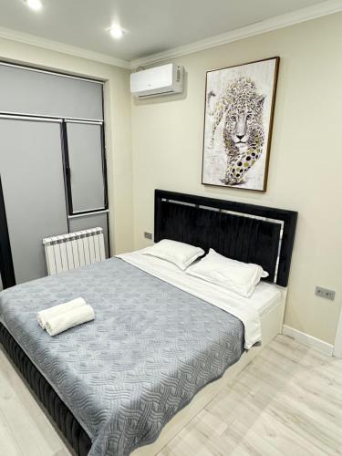 um quarto com uma cama grande e uma imagem na parede em Жк DIAL RESIDENCE возле Арбата и Мега центра em Almaty
