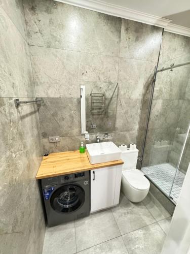 uma casa de banho com uma máquina de lavar roupa e um WC em Жк DIAL RESIDENCE возле Арбата и Мега центра em Almaty