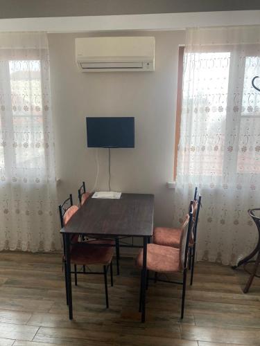 jadalnia ze stołem, krzesłami i telewizorem w obiekcie Apartment Pomorie w mieście Pomorie