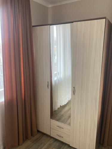 duża drewniana szafka z lustrem w pokoju w obiekcie Apartment Pomorie w mieście Pomorie