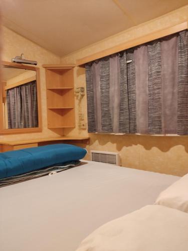 um quarto com uma cama e uma janela em Mobil home willerby de luxe em Le Portel