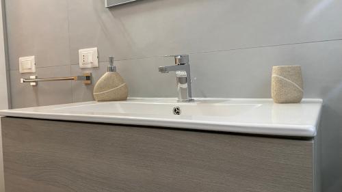 a bathroom sink with two soap dispensers on it at Elorino Chic&Relax in Rosolini
