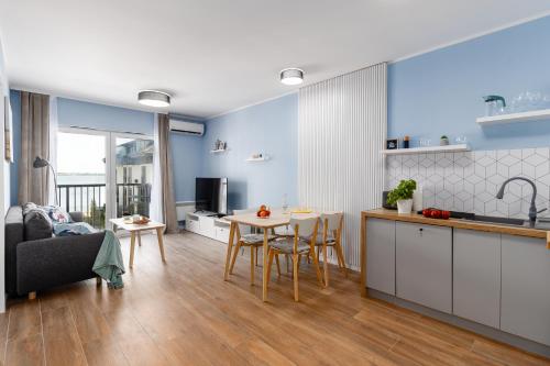 a kitchen and living room with a table and a couch at Apartament LANZAROTE Dziwnów Wybrzeże EPapartamenty in Dziwnów