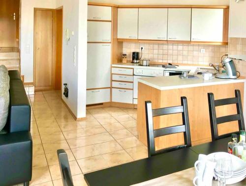 a kitchen with a counter top and a table and chairs at SEEnsation Classic - Mainaublick in Uhldingen-Mühlhofen