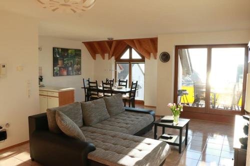a living room with a couch and a table at SEEnsation Classic - Mainaublick in Uhldingen-Mühlhofen