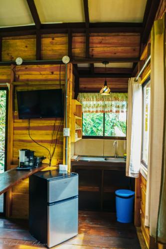 a kitchen with a sink and a tv in a room at Hospedaje La Naciente in Turrialba