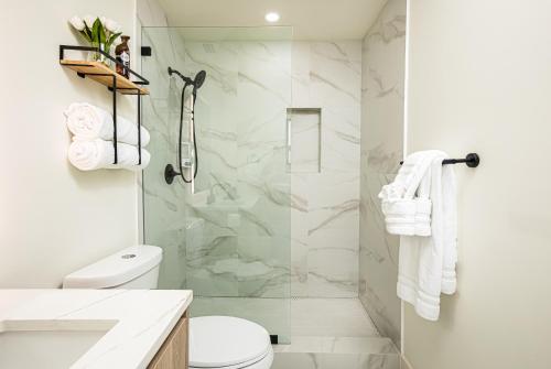 a white bathroom with a shower and a toilet at Black Vanilla - Stylish Symphony 3miles Downtown in Naples