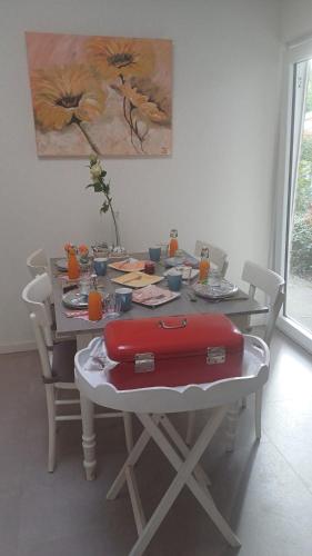 a dining room table with a red suitcase on it at Bed & Breakfast de Koepeltjes in Zoetermeer