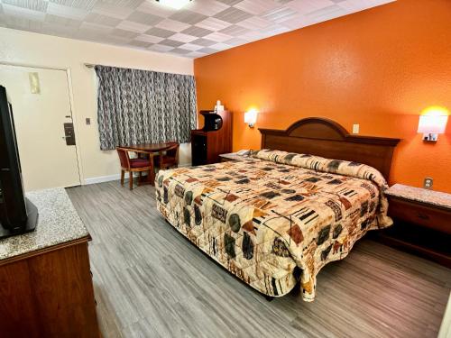 une chambre d'hôtel avec un lit et une télévision dans l'établissement Knights Inn Galax, à Galax