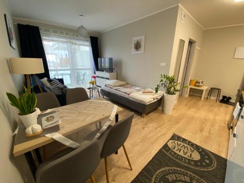 ein Wohnzimmer mit Tisch und Couch in der Unterkunft Apartament MIELCZARSKIEGO Elbląg in Elblag