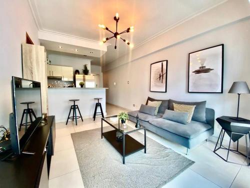 un soggiorno con divano blu e una cucina di Stylish 1br Apt in Piantini/Serralles, Santo Dgo a Santo Domingo