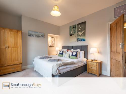 um quarto com uma cama e um armário de madeira em Mayville Lodge - STUNNING 3 BEDROOMED TOWNHOUSE WITH FREE PARKING em Scarborough