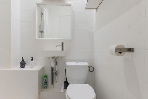 La salle de bains blanche est pourvue de toilettes et d'un lavabo. dans l'établissement Bel appartement tout équipé de 24m2, proche Paris, à Nanterre