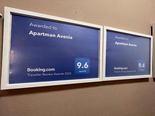 a sign that says upgraded to aprilanan aryanagency on a wall at Apartman Avenia in Novi Sad