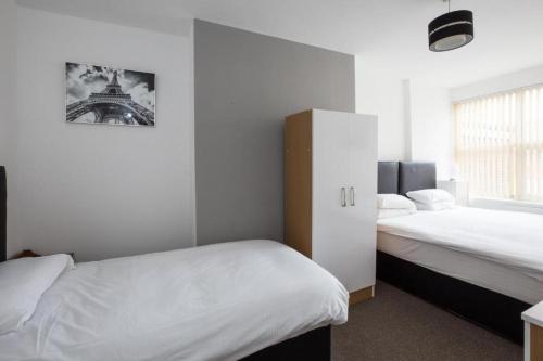 a bedroom with two beds and a picture of the eiffel tower at Grosvenor Hotel Rugby in Rugby