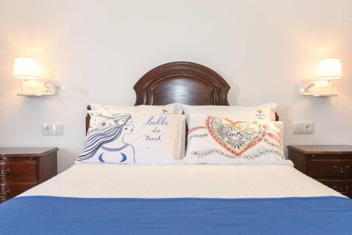 Una cama con dos almohadas y un cartel. en One bedroom house with shared pool terrace and wifi at Canico 1 km away from the beach, en Caniço