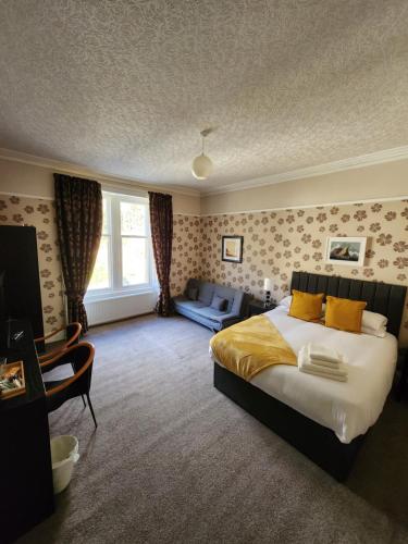 a bedroom with a large bed and a couch at King's Knoll Hotel in Oban
