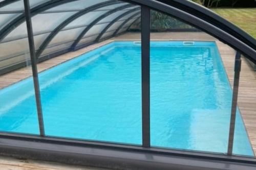 - une vue sur la piscine depuis la fenêtre dans l'établissement Le gîte Marie-Galante : Belle maison d'hôtes avec accès piscine en été, à Lanmeur