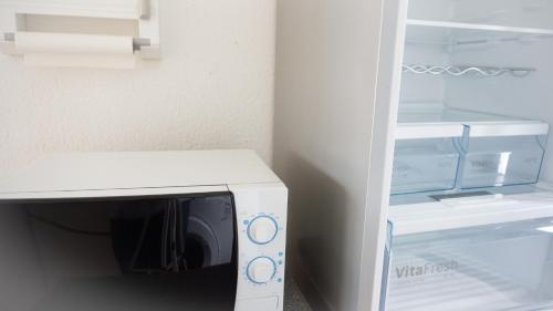 um micro-ondas ao lado de um frigorífico em CENTRAL Apartment Hannover - Good & calm location - Contactless Check-in em Hanôver