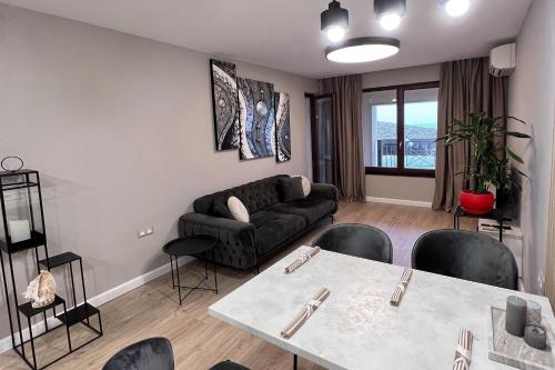 een woonkamer met een bank en een tafel bij Golden Sand Nelly apartment first line beach in Goudstrand