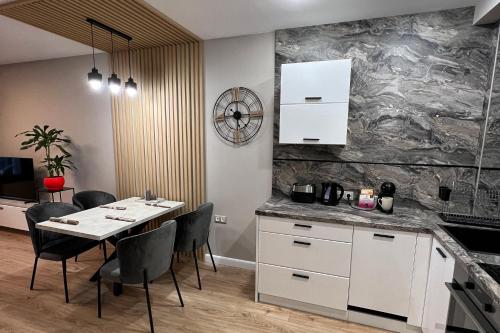 een keuken en eetkamer met een tafel en stoelen bij Golden Sand Nelly apartment first line beach in Goudstrand