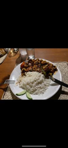 ein Teller mit Essen auf einem Tisch mit Reis in der Unterkunft Surangi in Kosgoda