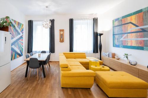 uma sala de estar com um sofá amarelo e uma mesa em Apartmán Praha Žižkov - DZ RENT em Praga