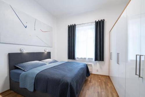 um quarto com uma cama e um relógio na parede em Apartmán Praha Žižkov - DZ RENT em Praga