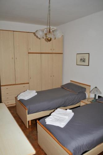 a room with two beds and a chandelier at Incantevole appartamento in un Castello storico in Croviana