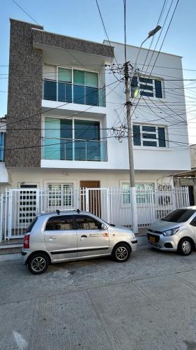 dos autos estacionados frente a una casa en Apartamento Amoblado Barranquilla San Jose, en Barranquilla