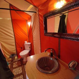 a bathroom with a sink and a toilet in a tent at Camel Experience Camp in Merzouga