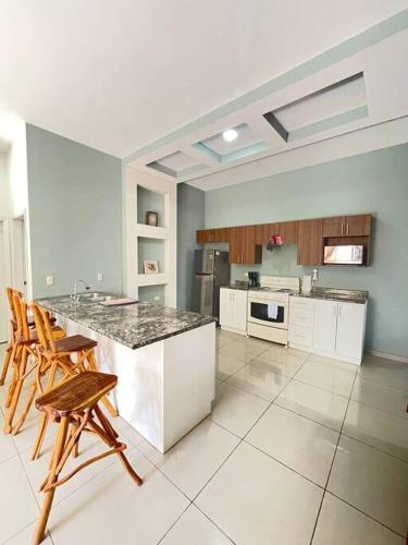uma cozinha com um balcão e algumas cadeiras em Casa privada, amplia y moderna. em Catacamas