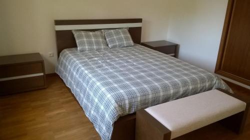 a bedroom with a bed with a plaid comforter at Buganvilias House in Praia de Mira