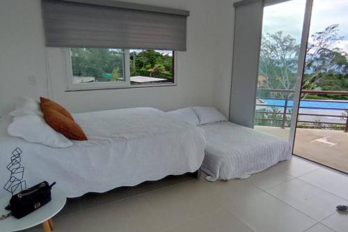 ein weißes Schlafzimmer mit einem Bett und einem Fenster in der Unterkunft Hermosa y Moderna Casa Campestre in La Mesa