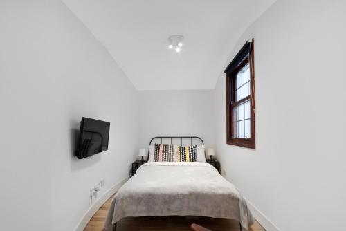 a white room with a bed and a window at Little Venice Studio By Morethanstays in London