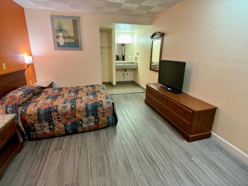 a hotel room with a bed and a flat screen tv at Knights Inn Galax in Galax