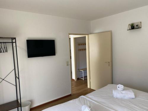 a bedroom with a bed and a television on the wall at Appartement Au Rhin mit Balkon in Bad Bellingen in Bad Bellingen