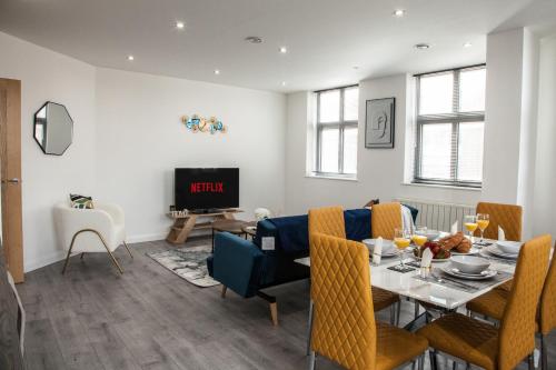 a dining room with a table and a tv at Cityscape 2-BR - Leicester's Premier Urban Retreat in Leicester