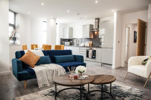 a living room with a blue couch and a table at Cityscape 2-BR - Leicester's Premier Urban Retreat in Leicester