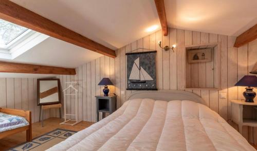 une chambre avec un grand lit et une fenêtre dans l'établissement Maison Koh Samet, à Saint-Trojan-les-Bains