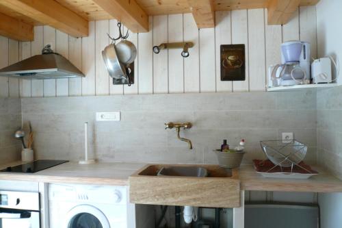 une cuisine avec un évier et un plan de travail dans l'établissement Maison Koh Samet, à Saint-Trojan-les-Bains