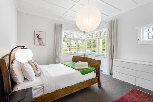 a white bedroom with a bed and a window at Riverhead Villa with BBQ and deck in Riverhead