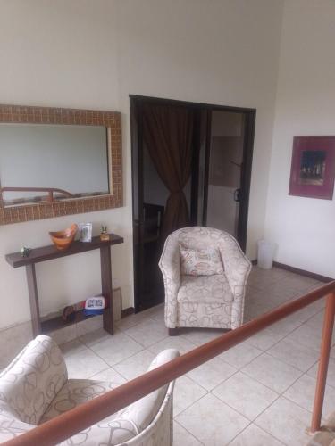 a living room with two chairs and a mirror at Hotel San Rafael Ecolodge in San Gerardo